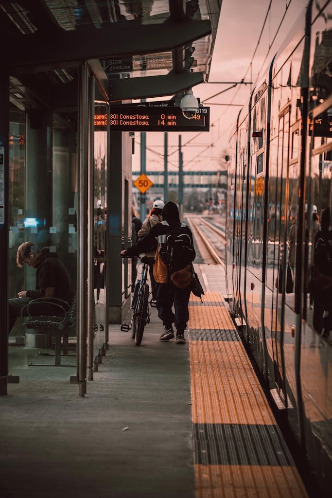 People at Waterloo train station platform with bicycles during dusk. Urban transport scene.